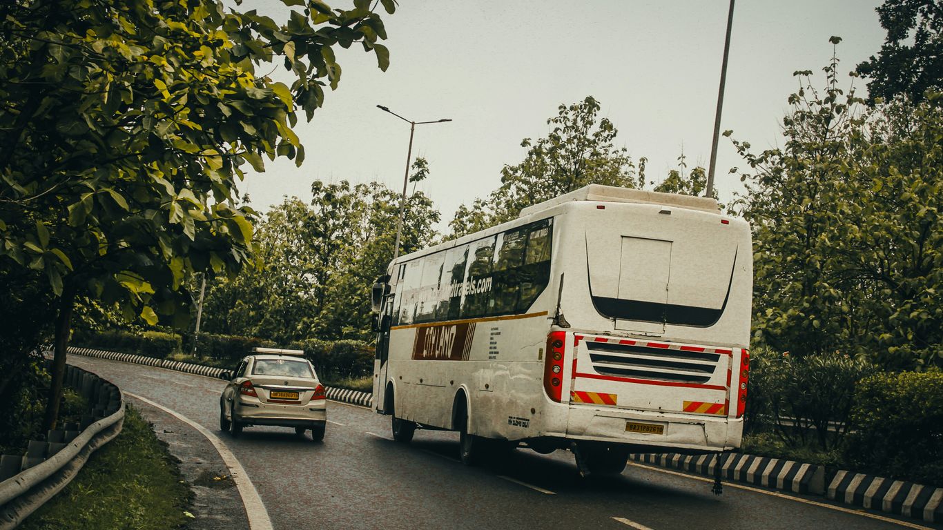 A bus and car travel along a road.